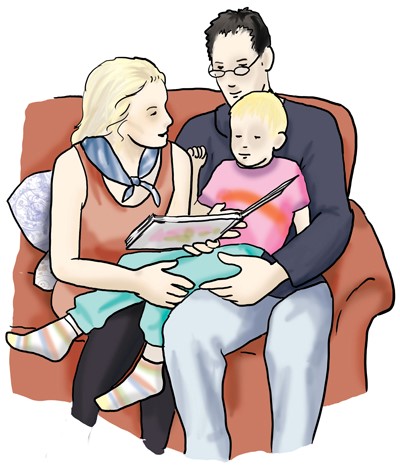 Eine Familie liest zusammen ein Buch auf dem Sofa
