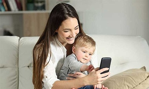 Mutter und Kleinkind schauen auf ein Smartphone