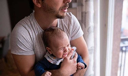 Vater hält weinendes Baby