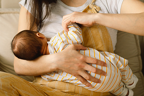 Mutter stillt ihr neugeborenes Baby