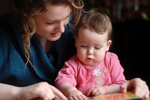 Mutter liest mit ihrem zehn Monate alten Baby ein Buch