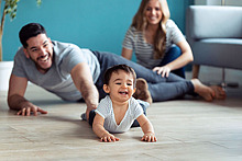Eltern spielen mit ihrem Baby auf dem Boden