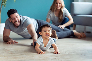 Eltern spielen mit ihrem Baby auf dem Boden