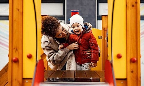 Mutter mit Kind auf dem Spielplatz 