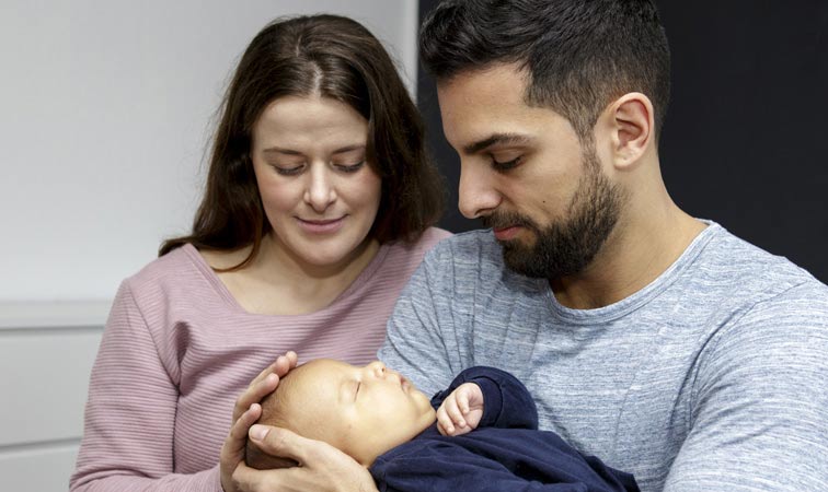 Mann und Frau mit Baby auf dem Arm