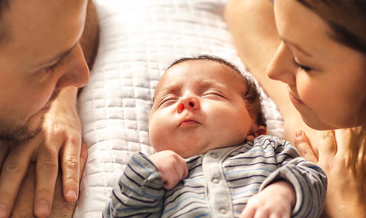 Eine Mutter und ein Vater schauen ihr Baby an