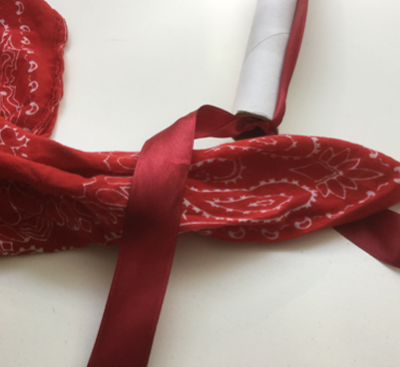 Pappröhre mit rotem Band und Tuch