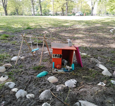 Kleine Holzschaukel und Häuschen in einem Steinkreis