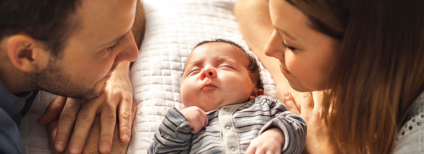 Eine Mutter und ein Vater schauen ihr Baby an