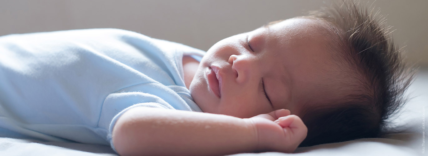 Ein Baby schläft auf dem Rücken