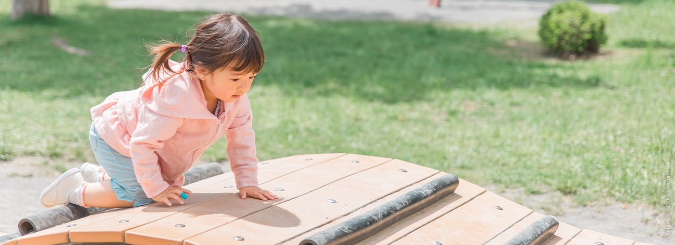 Mädchen klettert auf Spielplatz