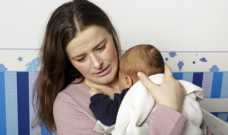 Mutter hält schreiendes Baby im Arm