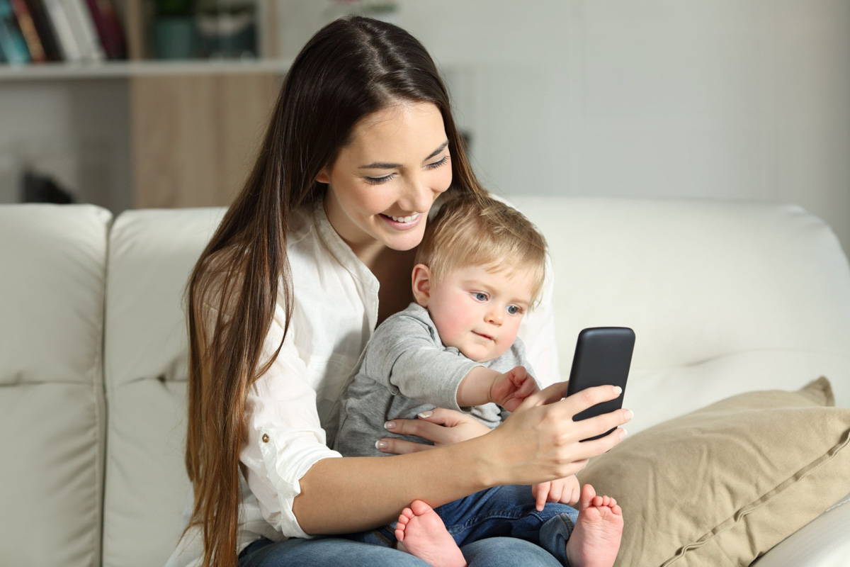 Mutter und Kleinkind gucken auf Smartphone