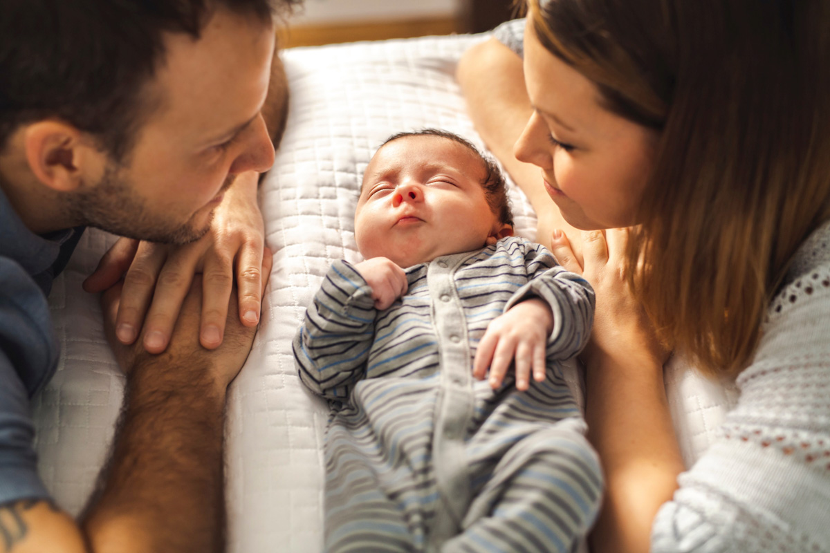 Eltern sein verändert die Partnerschaft. Eltern betrachten ihr neugeborenes Baby