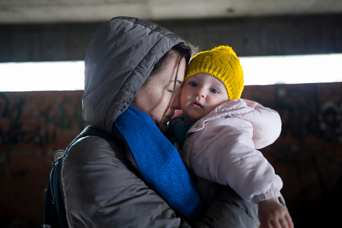 Beratung und Informationen für Familien aus der Ukraine Mutter mit Kleinkind auf dem Arm in einem Bunker
