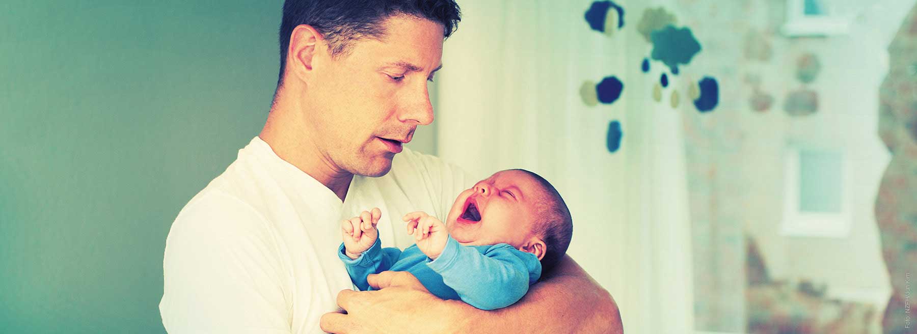 Motiv des NZFH zur Prävention von Schütteltrauma Vater mit Kind auf dem Arm