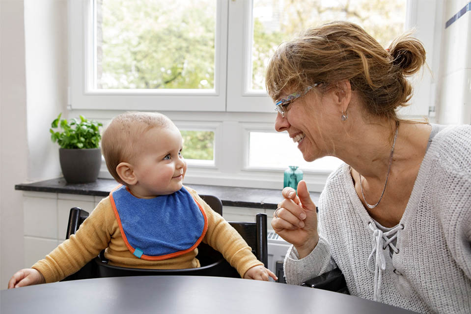 Baby strahlt Familienkrankenschwester an